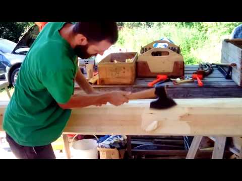 Me hewing log with swedish broad axe at gransfors bruks log cabin coarse