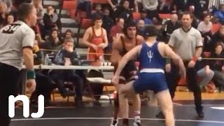 High School wrestler disqualified after punching opponent, pushing him into scorer's table