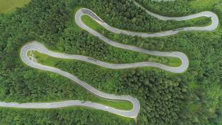 Aerial cars driving on mountain along scenic switchback road with hairpin turns
