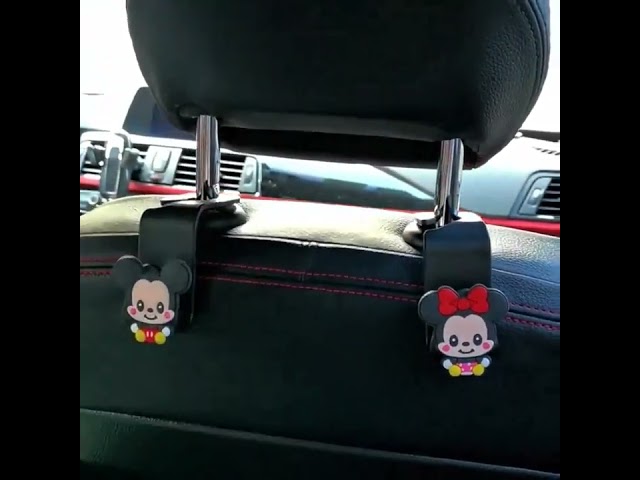 The 2pcs Universal Car Headrest Hook is a cute couple car hanger that can be used to hang and store items such as clothes in a car.