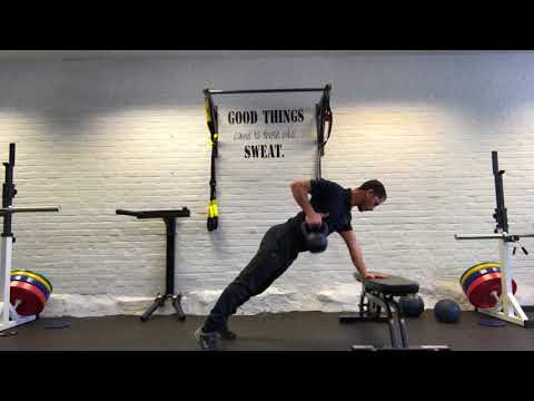 Kettle bell single arm row in a high plank position on the bench