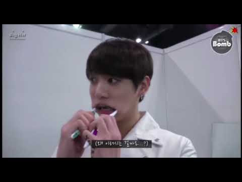 Jungkook brushing his teeth with 2 brushes