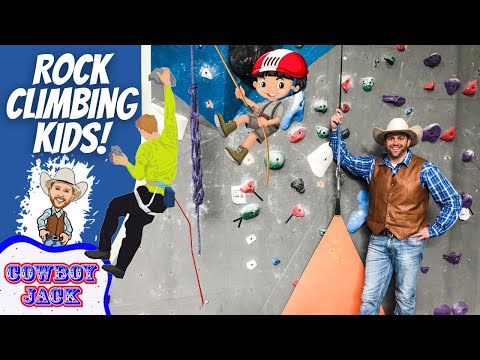 Banner promoting kids rock climbing with cartoon cowboys, a real instructor in a cowboy hat, and a climbing wall.