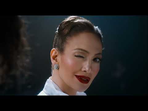 Final trailer beat: Molina and Valentín separated by bars as the Spider Woman’s silhouette fades