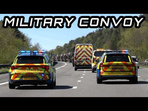 Police hold back traffic for large convoy of tank transporters