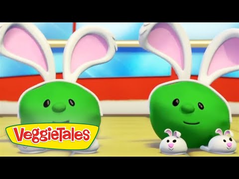 Two green VeggieTales characters wearing white bunny ears stand on a colorful stage with the VeggieTales logo in the lower-left corner.