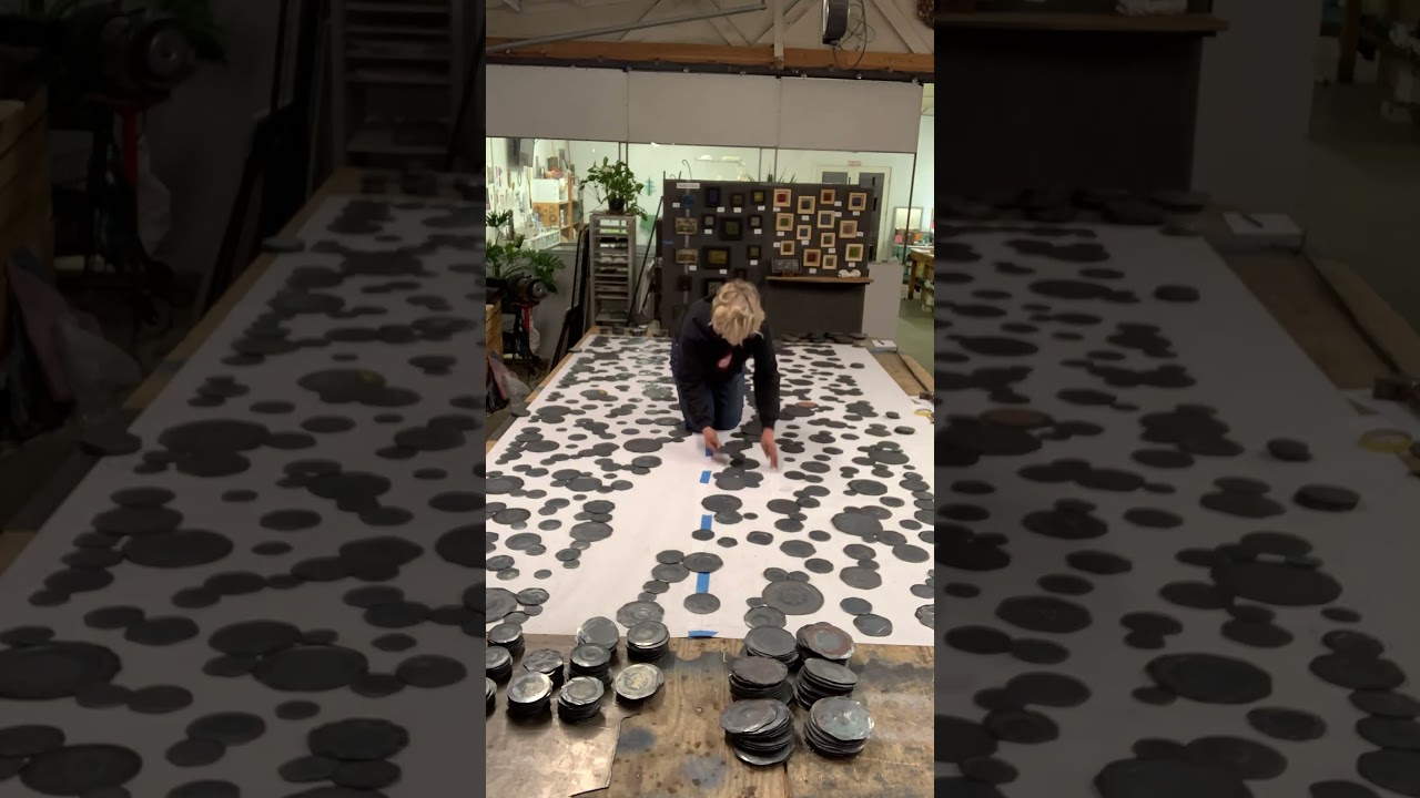 Artist Susan Madacsi works on laying out a large scale public artwork.