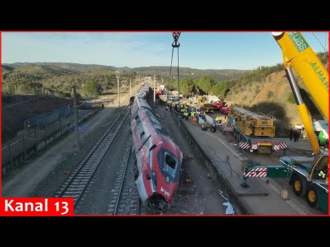 Drone footage shows cranes lifting Iryo train wreckage at train crash site in Spain