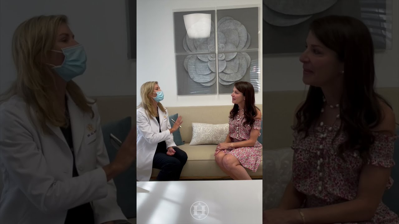 woman in lab coat talking to a patient on a couch