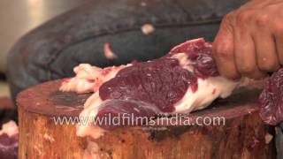 Butcher chopping meat from the sacrificed goat on the eve of Id-ul-Azha