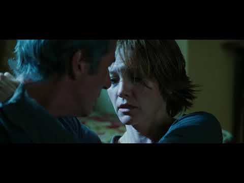 Official trailer still: the Inn at Rodanthe stands against storm-dark skies as surf pounds the pilings