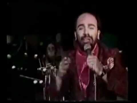 Το «Στο σκυλάδικο» (1989) του Γιάννη Ζουγανέλη, από τον διπλό δίσκο Αχ! Μαρία – Διπλός δίσκος ανοχής, ηχογραφημένο στην ομώνυμη σατιρική μουσική σκηνή των Εξαρχείων. Είναι ένα από τα σύντομα νούμερα μιας παρωδιακής περιήγησης στη νυχτερινή Αθήνα, από το «κουλτουριάρικο» και το «τζαζάδικο» έως το σκυλάδικο και την όπερα. Η σάτιρα δείχνει πώς αντιμετώπιζε το είδος η σκηνή του ηλεκτρικού τραγουδιού στα χρόνια της ακμής του.