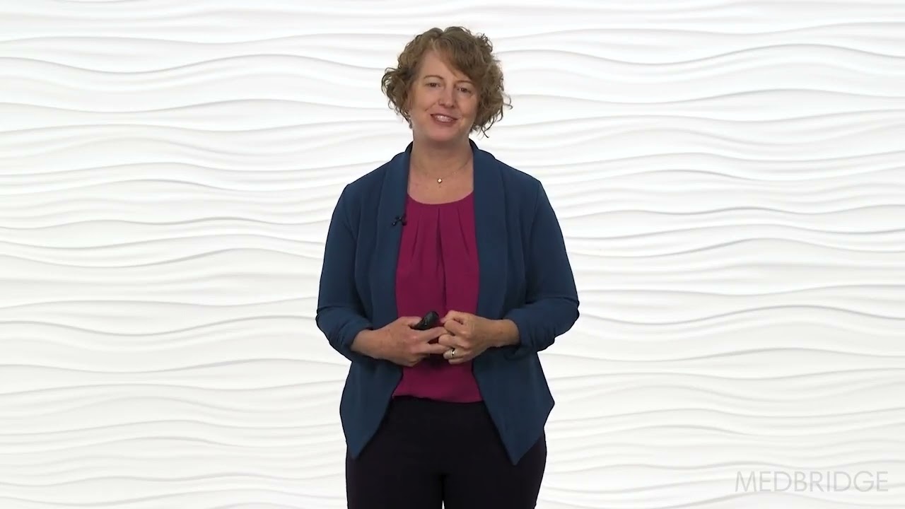 A woman holds a small object in front of a white background, wearing a blue jacket and red top, with the word "medbridge" in the corner.