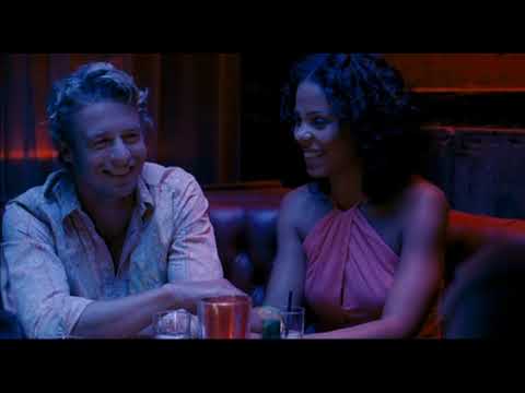 Trailer still of the tree kiss — rain-speckled branches framing the couple