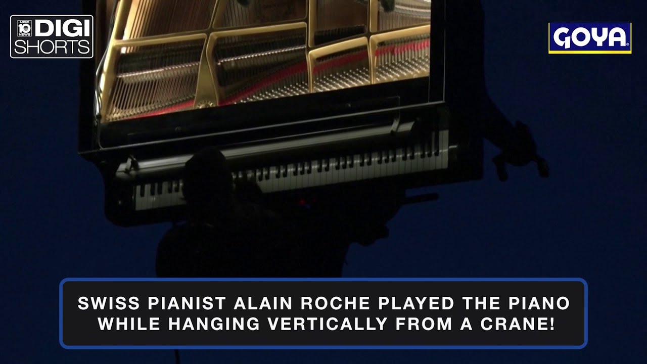 Swiss man plays piano while hanging vertically from crane