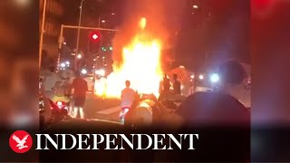 Rioters chase police car and set fire to street in The Hague