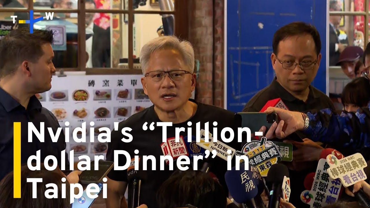 Jensen Huang surrounded by media and tech leaders at a dinner in Taipei