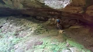 After riding the length of the rock shelter, the rider disappears behind a waterfall in the distance.