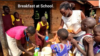 Children having breakfast with bread at school / African village school life .