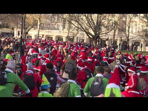 Video | Hundreds of cyclists dressed as Santa cycle through central London | AFP