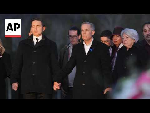 Mark Carney and opposition leader hold hands during Canada school shooting vigil