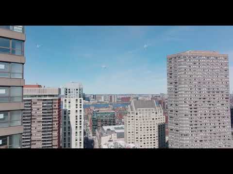 Forwards fly between high rise office buildings in city. Revealing panoramic view of Charles river