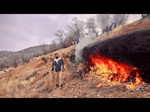 Fire Carving a Survival Shelter in Extreme Cold.Building Stone Shelter with Fireplace in Rainstorn