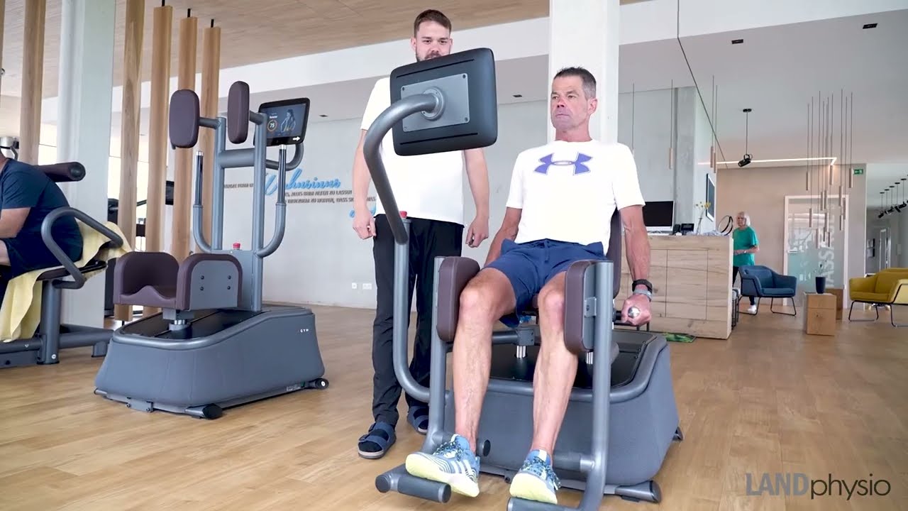 Mitglied sitz auf EGYM Gerät. Sporttherapeut LANDphysio Betreuung bei Kraftmessung