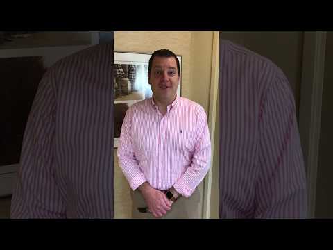 Man in pink and white striped shirt standing in dental office