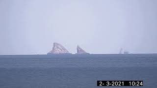 Ultra Tele-Zoom Camera at 16km distance rock in ocean.