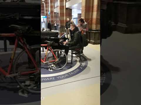 Strangers in Public Piano and Violin player perform classical music duet Amsterdam Central Station