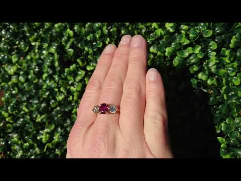 An 18 carat gold ruby and diamond trilogy ring