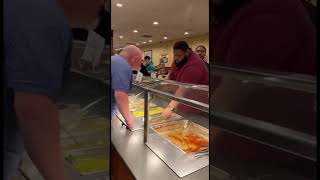 Two men fighting over the last piece of chicken at a buffet restaurant!￼