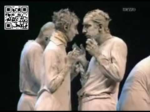 Απόσπασμα από το May B (1981), χορογραφία της Maguy Marin [Μαγκύ Μαρέν] εμπνευσμένη από το έργο του Samuel Beckett [Σάμιουελ Μπέκετ]. Οι χορευτές και οι χορεύτριες έχουν πρόσωπα και σώματα καλυμμένα με λευκό πηλό. Η θεατρικότητα συγκροτείται από τη χειρονομία, τις σχέσεις των σωμάτων και τους ήχους που παράγουν οι ίδιοι και οι ίδιες.