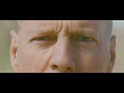 Looper 2012 official trailer still with Joseph Gordon-Levitt aiming a gun
