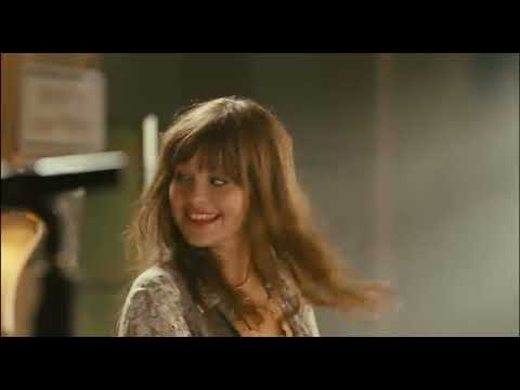 Trailer still — the band Rock It playing in a school gym under blue wash lights