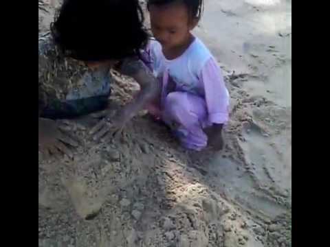 Alifa bermain pasir di pantai bokori
