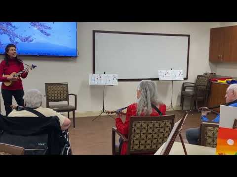Melanie Kareem teaching seniors how to play Ukulele