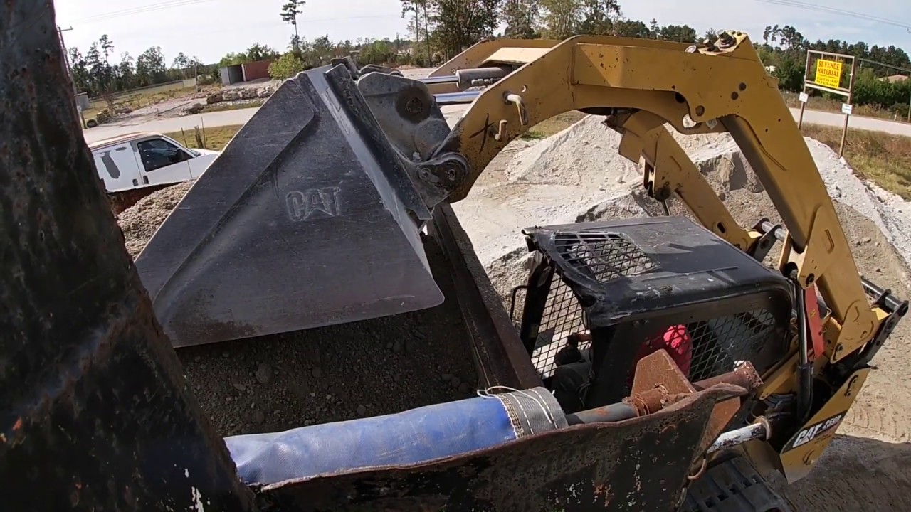 CAT 259D track loader skidsteer, loading dump truck / chevy truck stuck in mud.