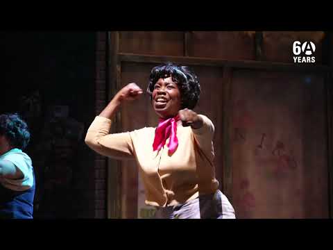 Closing trailer frame with Audrey II’s blossom grinning as the company readies the finale