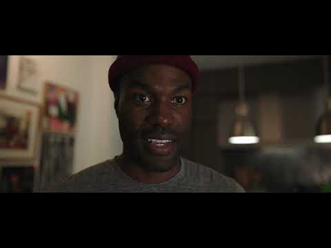 Candyman 2021 trailer frame with Anthony in gallery space under ominous lighting