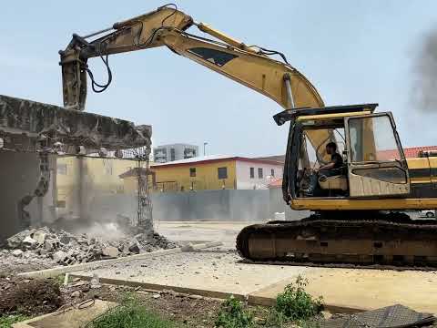 Caterpillar 325B destroying a house