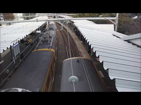 Trains departing from the station seen from above Seibu Hajima line