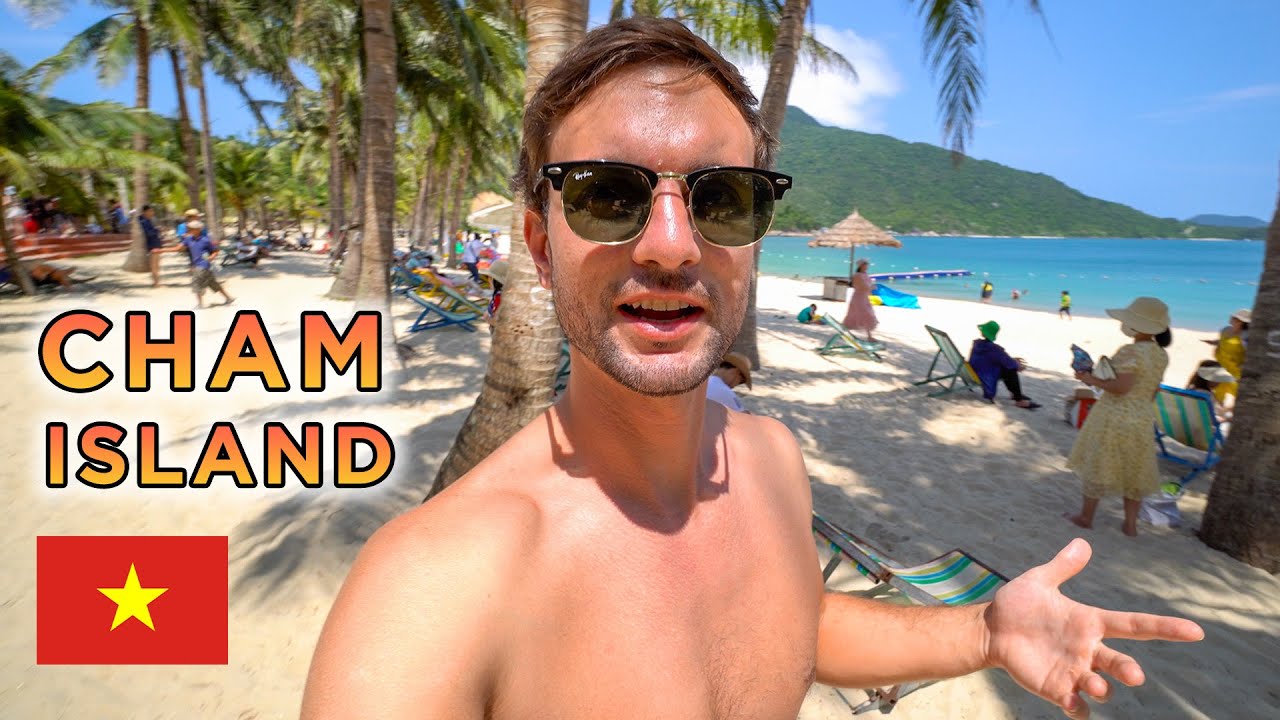 Tourist visits Cham Islands, discovering pristine beaches and lush greenery.