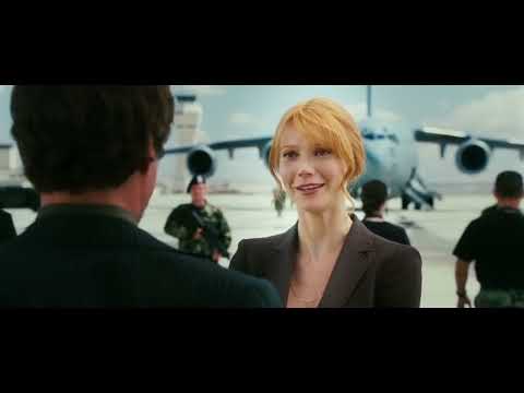 Iron Man (2008) trailer frame: Tony Stark in Mark III lift-off—electric-guitar score meets hard-rock swagger
