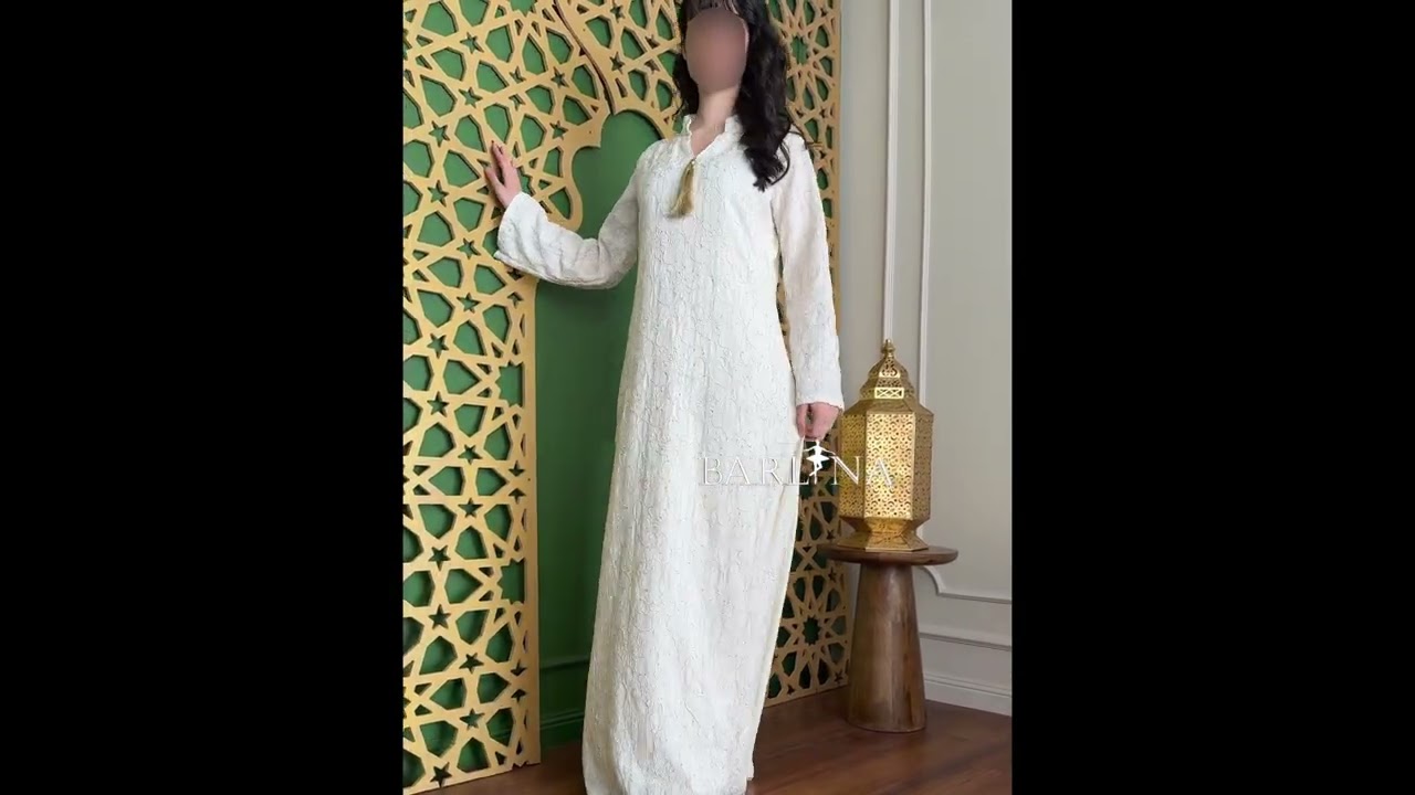 A white jalabiya with delicate embroidery and a straight cut. - L