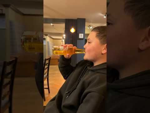 Kid pretends to drink beer in pub (It’s Apple juice)