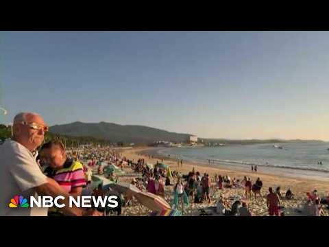 Beachgoers in Spain revel in total solar eclipse