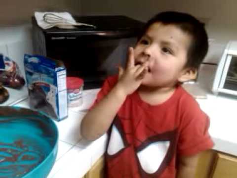 Baby boy eat cake mix off his hand