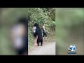 Woman takes selfie as bear sniffs her hair on hiking trail in Mexico